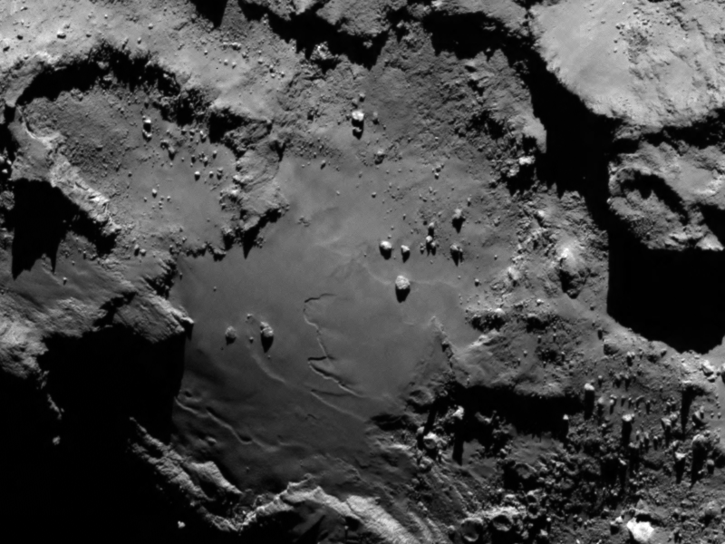 Detale komety sfotografowane przez aparat o wąskim polu widzenia OSIRIS 6 sierpnia 2014 roku. Na zdjęciu widać gładki obszar na podstawie „korpusu” komety 67P/Czuriumow-Gierasimienko. Widać dobrze szczegóły terenu – kratery, zbocza i ostre klify. Rosetta sfotografowała kometę z odległości 130 km, jeden piksel odpowiada 2,4 m. Fot. ESA/Rosetta/MPS for OSIRIS Team MPS/UPD/LAM/IAA/SSO/INTA/UPM/DASP/IDA