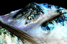 Brązowe smugi to ślady spływającej ma Marsie wody. Obraz powstał z nałożenia zdjęć zrobionych w podczerwieni na przestrzenną mapę Marsa. Kolory nie oddają rzeczywistości, uwydatniają za to skład gruntu. Skala pionowa jest tu powiększona 1,5 raza. Fot. NASA/JPL/University of Arizona