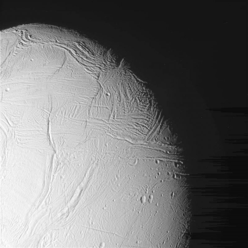 Lodowa powierzchnia Enceladusa sfotografowana przez sondę Cassini. Na nieobrobionym zdjęciu po prawej widoczne są artefakty w postaci ciemniejszych linii. Fot. NASA/JPL-Caltech/Space Science Institute