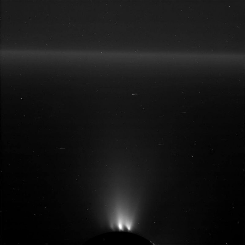Widok lodowego gejzera tryskającego z południowego bieguna Enceladusa. Zdjęcie nieobrobione, widać smugi wynikające z długiej ekspozycji. Fot. NASA/JPL-Caltech/Space Science Institute