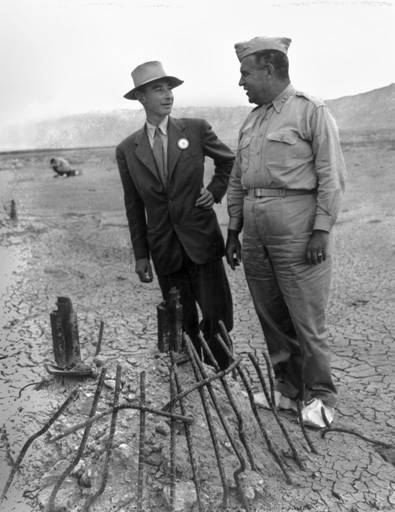 Robert Oppenheimer wraz z Lesliem Grovesem (wojskowym szefem Projektu Manhattan) nad pozostałością jednej z podpór wieży, na której umieszczona była bomba. Zdjęcie zrobiono we wrześniu 1945 roku. Fikuśne butki Grovesa to ochraniacze mające zapobiec przenoszeniu skażonej ziemi.